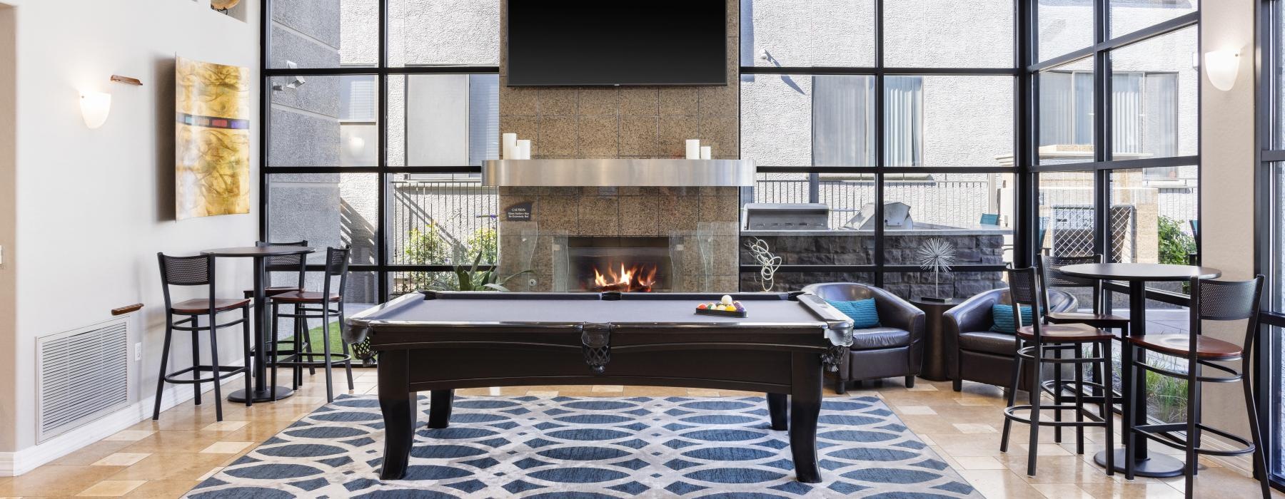 a room with a fireplace and chairs and a pool table